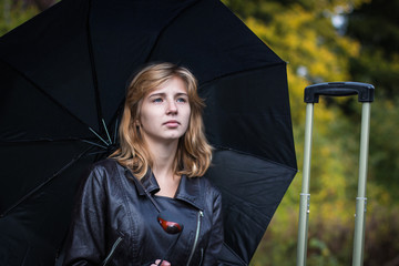 Girl with the black umbrella in autumn day