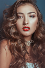 Fototapeta premium Beautiful caucasian girl with curly long hair and luxury makeup with accessories on a neck