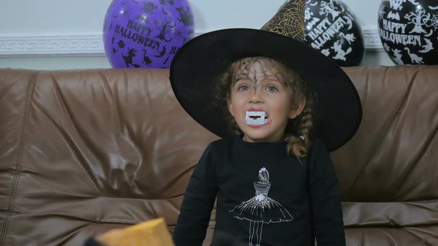 Little with false teeth try to scary on Halloween