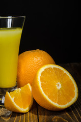 glass of juice, orange on a black background
