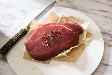 Raw beef tenderloin with peppercorns