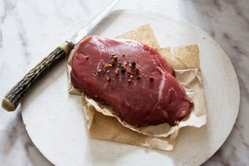 Raw beef tenderloin with peppercorns