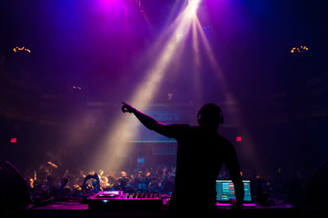 Silhouette of a DJ performing at a concert - obrazy, fototapety, plakaty