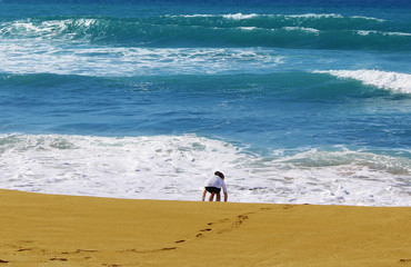 Little girl playing at the beach in the day time