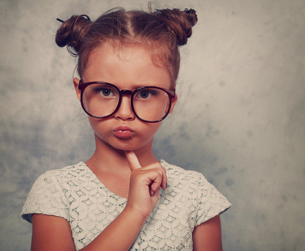Serious angry kid girl with modern hair style in fashion glasses
