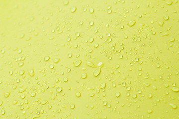 Drop of water on yellow background