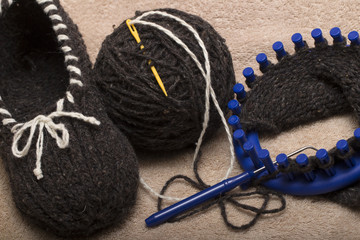  the process of knitting wool slippers gray yarn on a circular loom