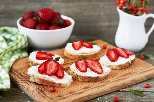 Canape with cottage cheese and strawberry on a cutting  board, horizontal,