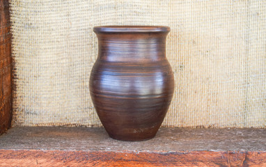 Clay pot on a shelf. Shelves with standing on their utensils of porcelain and earthenware. Vintage kitchen utensils