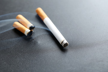 Cigarette with ash on black background