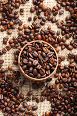 Brown roasted coffee beans in bowl on sackcloth
