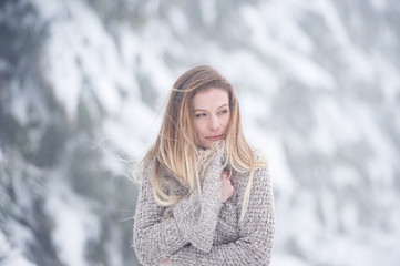 Beautiful young woman on a walk in winter nature