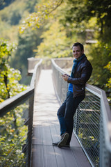 Fototapeta premium Caucasian man with cell phone making call in beautiful place at nature park outdoors