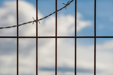 barbed wire fence against a blue sky
