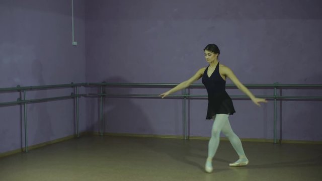 Pretty ballerina making a pose in a hall