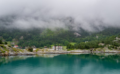 Houses of norwegian village at fjord's shores .