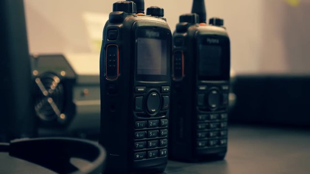 Two walkie-talkie on the table. Dolly shot. Shallow depth of field