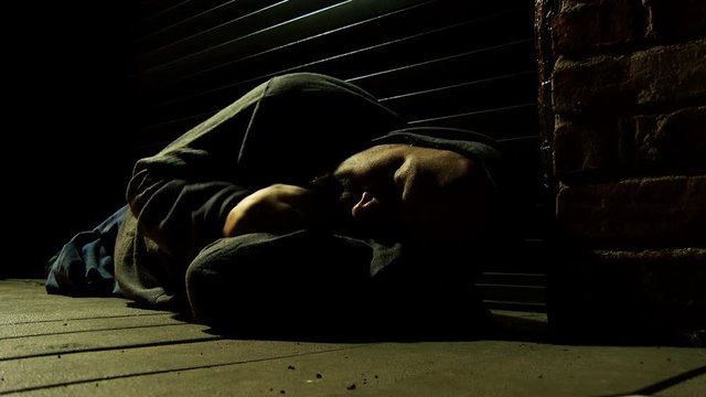 Homeless sleeping in alley at night.