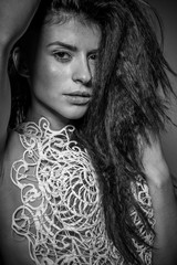 Sexy brunette with long braided hair dressed with white corset s