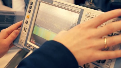 Scientist working with an electronic measuring device and see the results in the form of sine waves on the display equipment