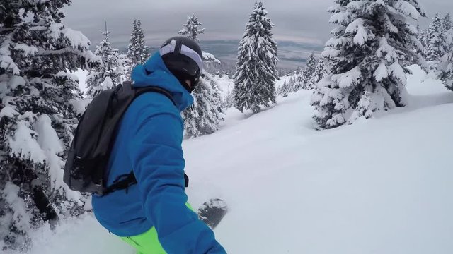 SELFIE CLOSE UP: Snowboarder riding fresh powder and falls down into snow
