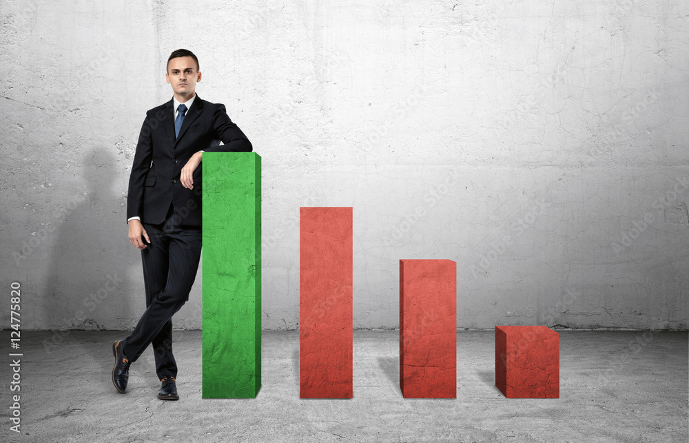Poster businessman standing on the floor next to large columns of graph