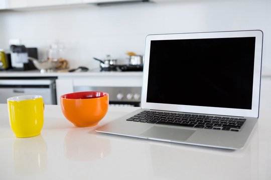 Breakfast Bowl With Coffee Mug And Laptop In Kitchen