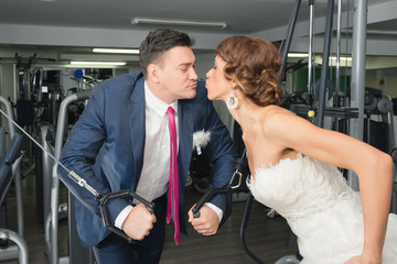 Bride and groom kissing in gym