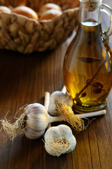 head of garlic and olive oil bottle on a rustic table