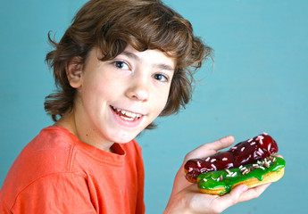 handsome boy with eclair french dessert in hands