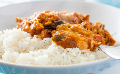 Close-up view of Ghanaian groundnut stew with long grain rice in a white bowl