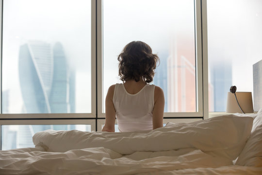 Young woman enjoying city view after waking up