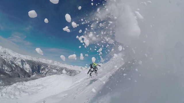 SLOW MOTION: : Happy snowboarder having fun riding powder snow in backcountry