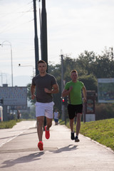 Two young men jogging through the city