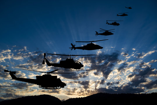 Flying army helicopters on sunset background