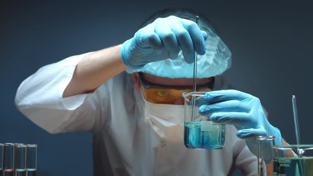 Chemist stirs transparent liquid in beaker with glass stirring rod and it became blue, chemistry experiment