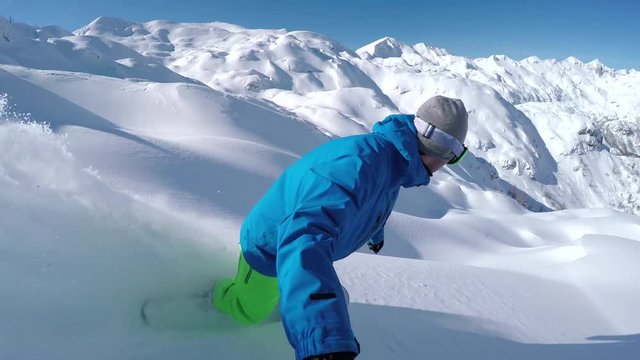 SELFIE: Extreme freeride snowboarder riding powder off-piste and falls into snow