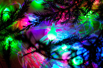 Obraz na płótnie Canvas out of focus colored lights and garlands of Christmas tree branc