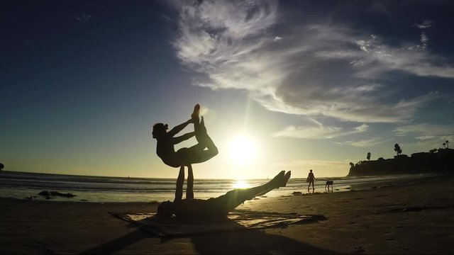 Acroyoga on beach at sunset 60fps.