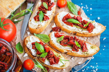 Bruschetta with cream cheese, pesto, fresh basil and sun dried t