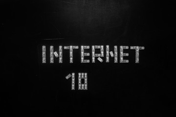 Word "Internet" and numeral "10", made of connectors RJ45 for LAN isolated over the black scratched board background.