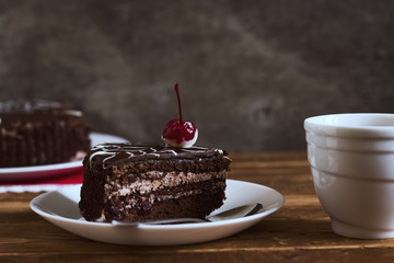 Chocolate cake with tea on dark background. Small depth of field, toned image, selective focus
