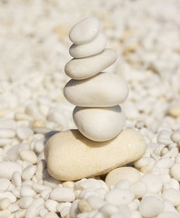 Stones balance on beach, white marble