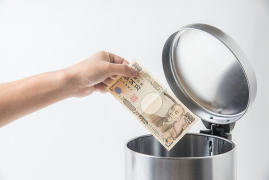 throwing away japanese yen  in trashcan