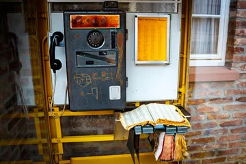 Fotobehang Oude telefooncel met telefoonboek © Matthias