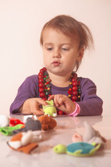  little cute  girl playing  indoorswith colored toys (developmen