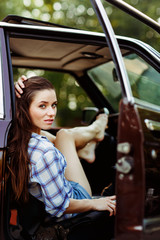 Fototapeta na wymiar Serious brunette in burgundy car , tinted photo