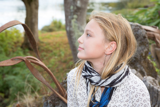 Pensive And Young Blonde Teen Girl In Park