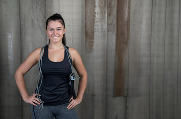 attractive woman with jumping rope against rustic background