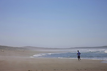 Fototapeta na wymiar man running on wide beach